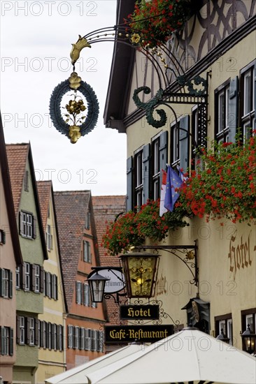 Late medieval townscape with hotel and nose sign