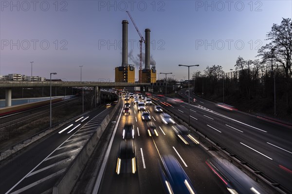 Congested traffic on the A100 with a view of the Wilmersdorf combined heat and power plant looms at blue hour in Berlin