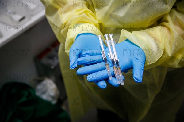 A staff member shows syringes raised with Moderna Spikevax vaccine at a COVID-19 vaccination and testing centre at Autohaus Olsen in Iserlohn