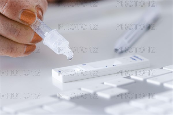 Symbol photo on the subject of ' Compulsory testing in the office'. A Sars Covid-19 antigen rapid test lies on the keyboard of a computer. Berlin