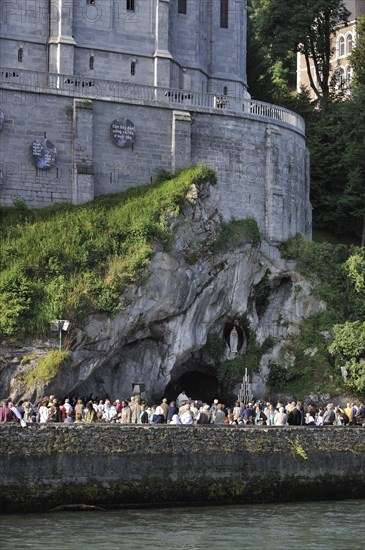 Pilgrims praying in front of the grotto at the Sanctuary of Our Lady of Lourdes