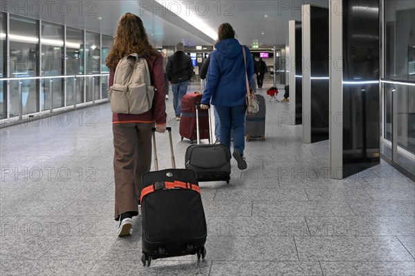 Travellers with rolling suitcases