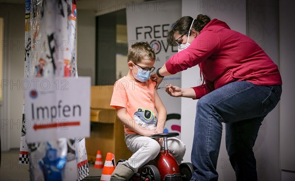 A boy is vaccinated by a doctor with the BioNTech Pfizer children's vaccine at a COVID-19 vaccination and testing centre at Autohaus Olsen in Iserlohn