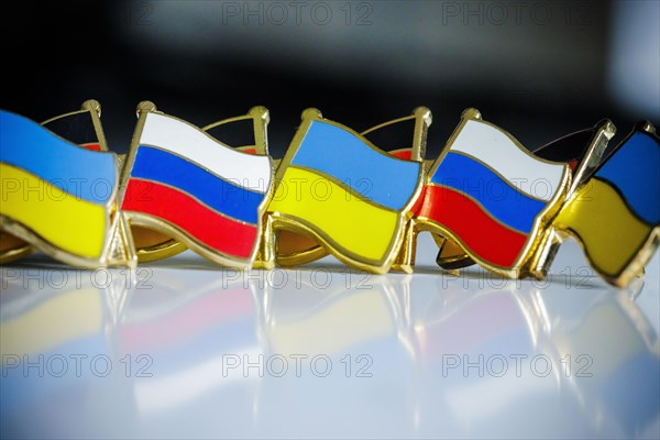 Symbolic photo on the topic ' Diplomacy between Russia and Ukraine '. Pins with the national flags of Russia and Ukraine stand on a table. Berlin