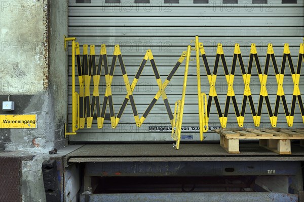 Barrier fence in front of a rolling gate in a former paper factory