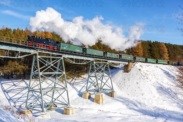 Steam train of the Fichtelbergbahn railway Steam locomotive on a bridge in winter in Oberwiesenthal