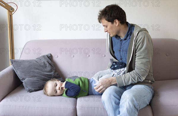 Subject: Father dresses a child aged nine months