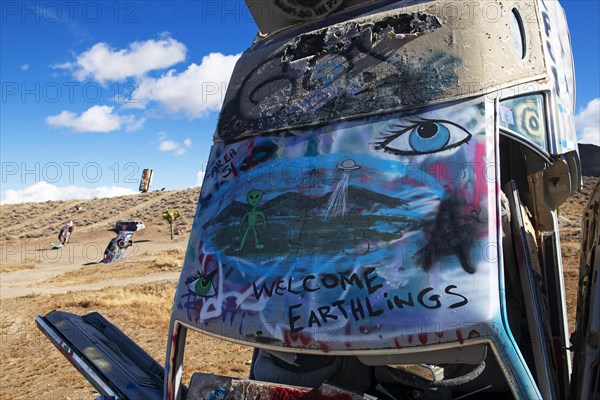 Cars sunk into the ground and sprayed with graffiti