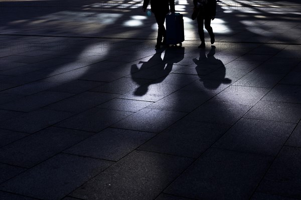 The silhouette of travellers stand out in front of the main station in Berlin