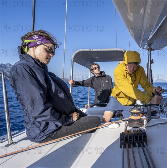 Sailor operating a winch with halyard stopper