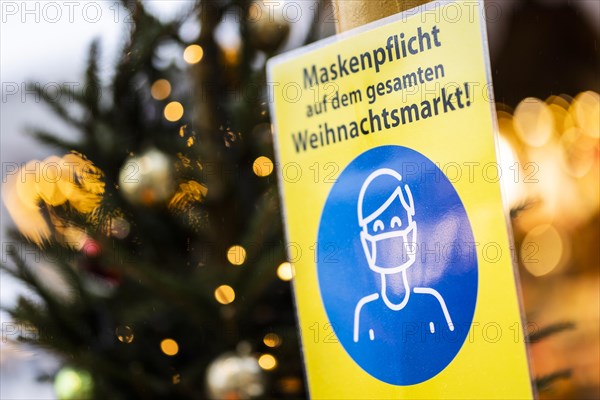 A sign indicating that masks are compulsory stands out at the Christmas market on Alexanderplatz in Berlin