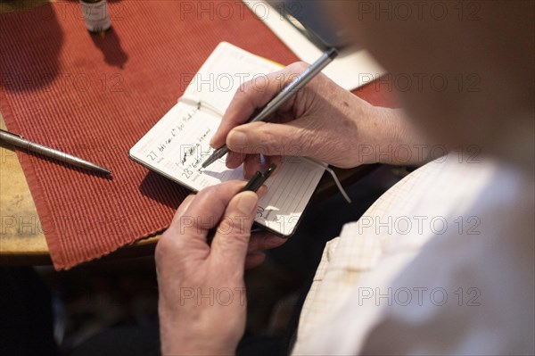 Dementated man taking notes in a notebook