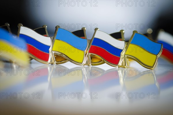 Symbolic photo on the topic ' Diplomacy between Russia and Ukraine '. Pins with the national flags of Russia and Ukraine stand on a table. Berlin