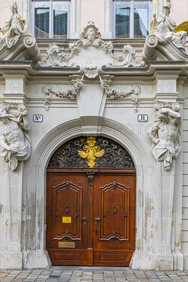 Round arched front door framed with stone figures