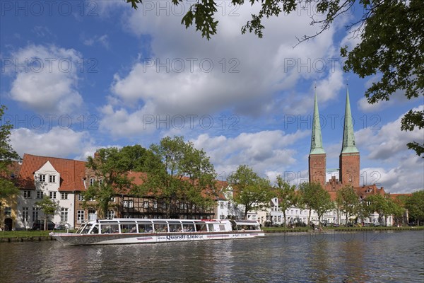 Tourist boat on the river Trave and the Luebeck Cathedral