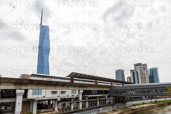 Metro train of the LRT Kelana Jaya Line at the Pasar Seni stop and skyscraper Merdeka PNB 118 Tower in Kuala Lumpur