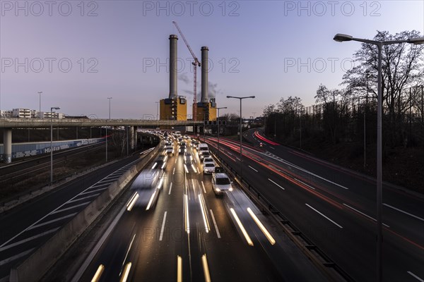 Congested traffic on the A100 with a view of the Wilmersdorf combined heat and power plant looms at blue hour in Berlin