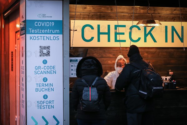 Two people are checked in by an employee of a COVID-19 test centre for a Corona test in the old town of Duesseldorf