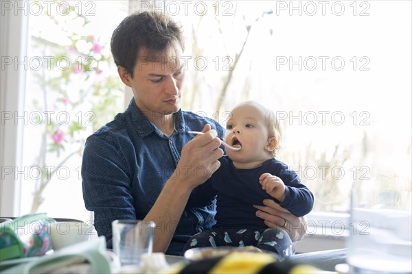 Subject: Father feeding his child at the age of nine months.