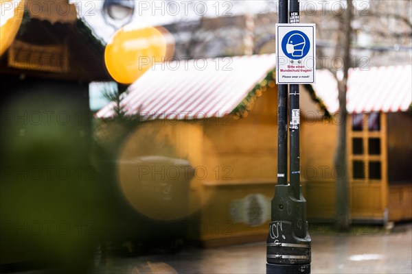 A sign indicating that masks are compulsory stands out at the Christmas market on Breitscheidplatz in Berlin