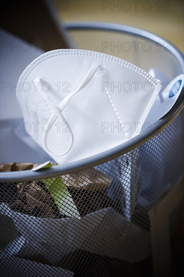 Symbolic photo on the topic ' End of mandatory masks '. An FFP2 mask lies in a dustbin. Berlin