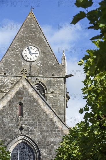 Sainte-Mere-Eglise church with Parachute Memorial in honour of paratrooper John Steele who was caught on the church spire during D-Day