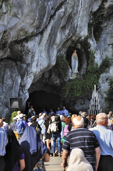 Pilgrims praying in front of the grotto at the Sanctuary of Our Lady of Lourdes