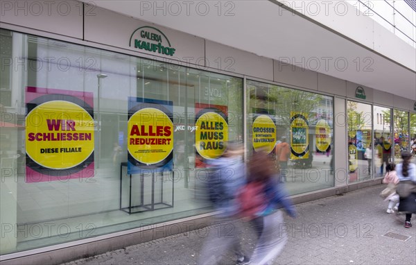 People walk in front of shop windows of a Galeria Kaufhof store