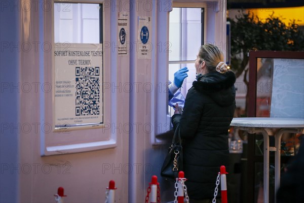 A staff member of a COVID-19 testing centre takes a throat swab for a Corona test from a woman in Duesseldorf