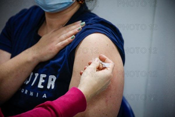 A woman is vaccinated by a doctor with the BioNTech Pfizer vaccine at a COVID-19 vaccination and testing centre at Autohaus Olsen in Iserlohn