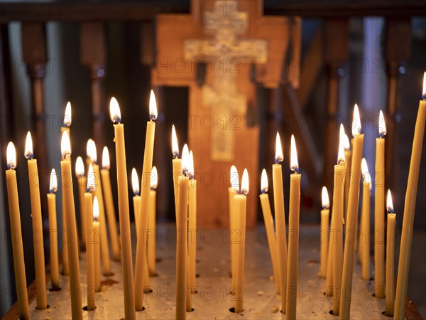 Burning candles in front of a cross in the Russian Chapel