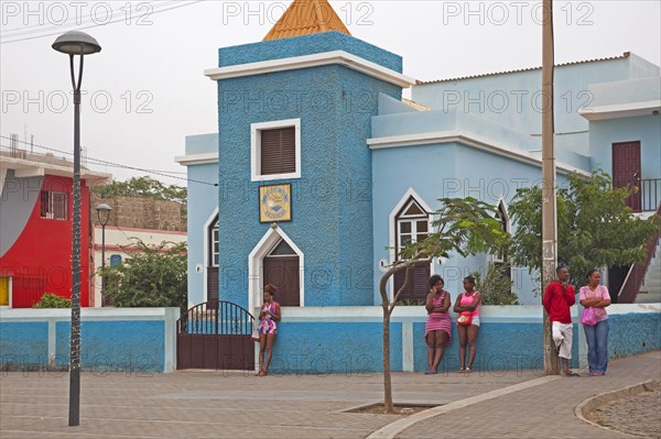 Creole man and women in front of the blue Esparagos church