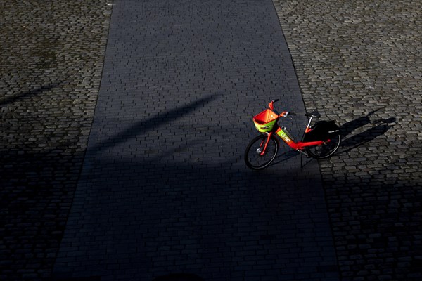 A rental bike from Lime stands on crosswise on the footpath in Berlin