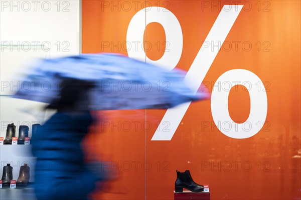 A person stands in front of a percentage symbol in Berlin