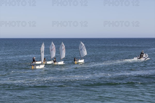 Optimist type dinghies of a sailing school sailing in the Atlantic Ocean off the coast of Lagos