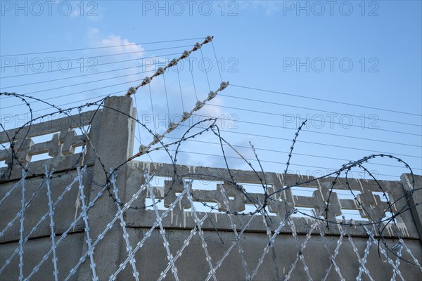 Barbed wire around cement wall