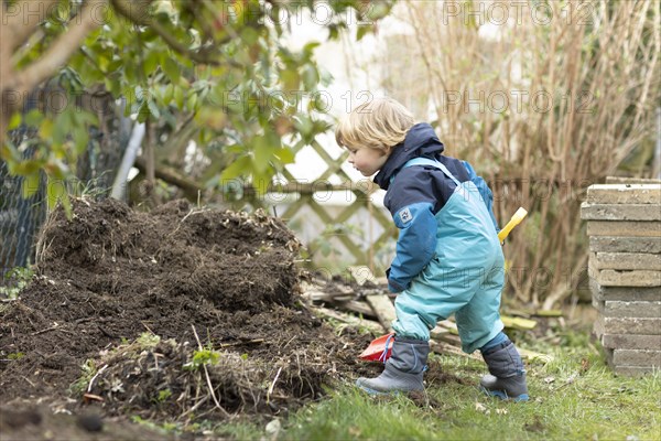 Toddler digging at a pile of earth