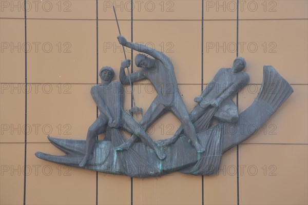 Sculpture with three fishermen fishing and fighting with pike
