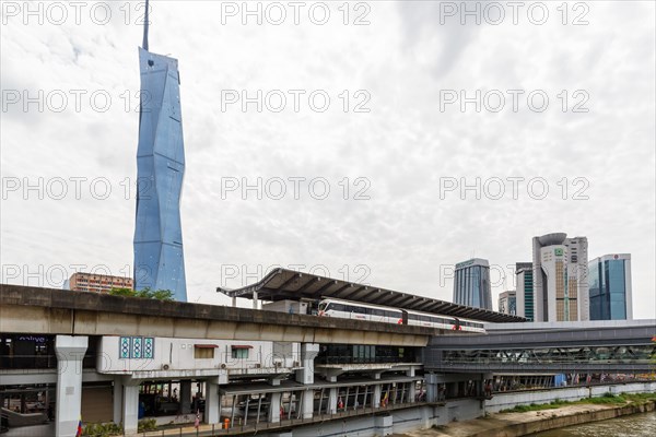 Metro train of the LRT Kelana Jaya Line at the Pasar Seni stop and skyscraper Merdeka PNB 118 Tower in Kuala Lumpur