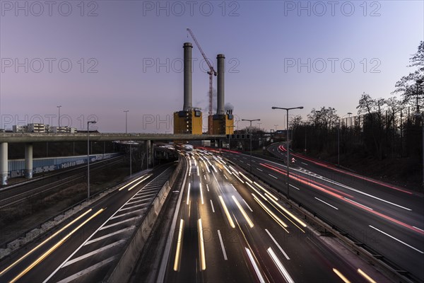 Congested traffic on the A100 with a view of the Wilmersdorf combined heat and power plant looms at blue hour in Berlin