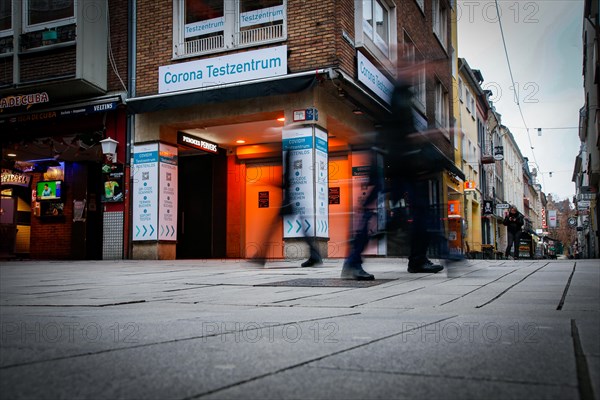 Passers-by pass a COVID-19 test centre in the old town of Duesseldorf