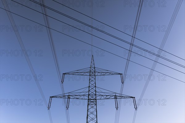 Electricity pylons silhouetted against a blue sky in Kaden