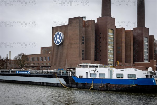 A cargo ship passes the plant of the car manufacturer Volkswagen