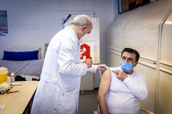 A pharmacist vaccinates a man with the Comirnaty BioNTech vaccine against the coronavirus in a pharmacy in Duesseldorf