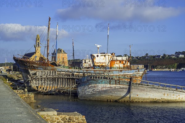 Tourists visiting wrecks of old wooden trawler fishing boats