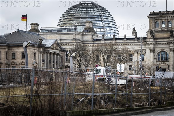 The German Bundestag looms behind an area cordoned off with construction fences in Berlin