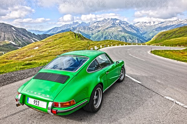 Classic Car Porsche 911 drives on high alpine mountain road Grossglockner-Hochalpenstrasse