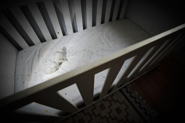 Symbolic photo on the subject of child abuse. A stuffed animal lies in an empty cot. Berlin
