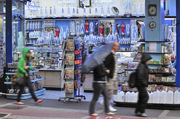 People buying religious souvenirs in souvenir shop near the Sanctuary of Our Lady of Lourdes