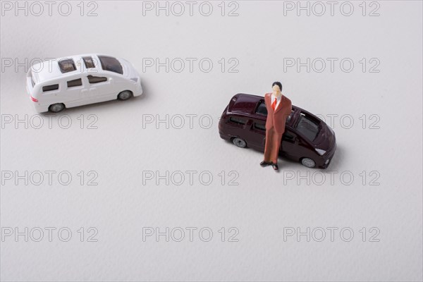 Tiny figurine of man miniature before a car